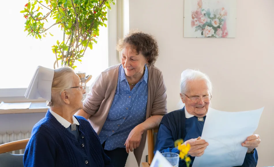 Pflegerin unterhält sich mit zwei diakonischen Schwestern