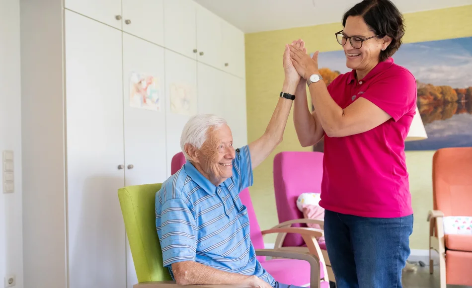 Pflegerin und alter Mann bei einer therapeutischen Übung