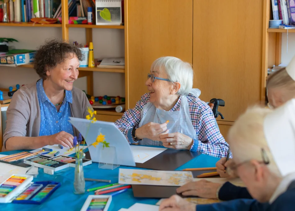 Bewohnerinnen der Altenpflege malen etwas